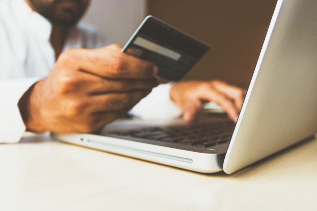 Hombre introduciendo datos bancarios en portátil, víctima de phishing bancario, caso que gestiona Bufete Paredes & Asociados