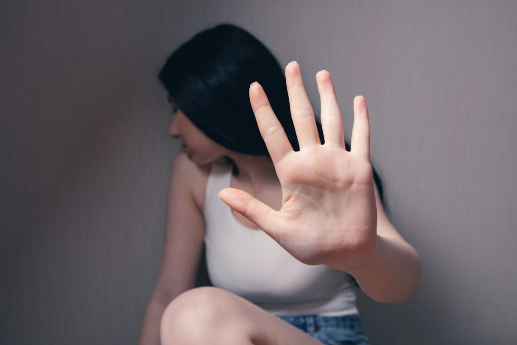Mujer protegiéndose con la mano al solicitar una orden de protección en Madrid, caso asesorado por Bufete Paredes & Asociados