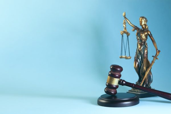 Bufete Paredes & Asociados defiende casos de estafa agravada junto a la balanza de la justicia y mazo judicial dorado