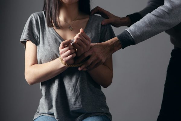 Mujer con manos atadas siendo retenida, caso de agresión sexual que Bufete Paredes & Asociados puede ayudarte a denunciar en Madrid