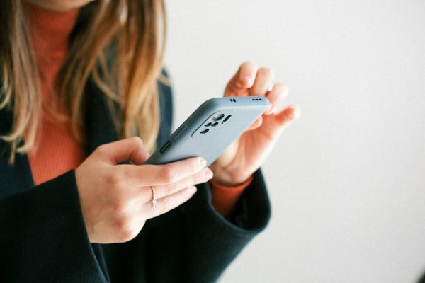 Mujer conservando mensajes amenazantes en WhatsApp, caso que Bufete Paredes & Asociados asesora antes de denunciar en Madrid